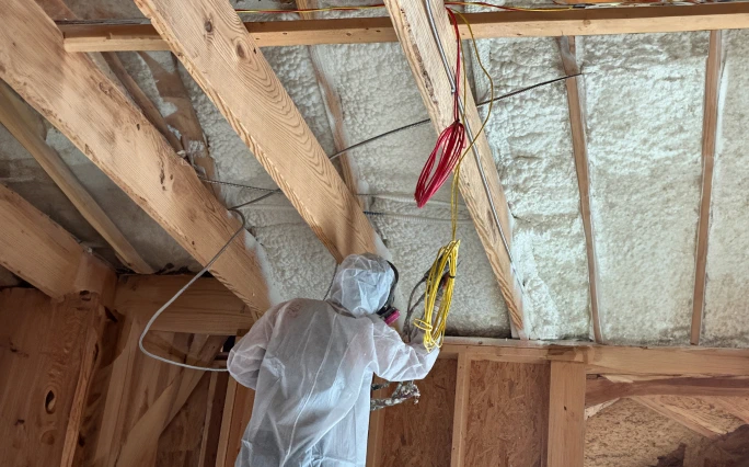 Spray foam technician applying product.