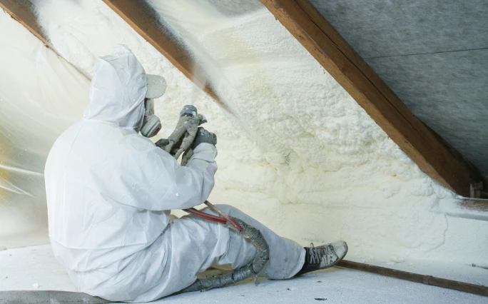 Spray foam technician applying product.