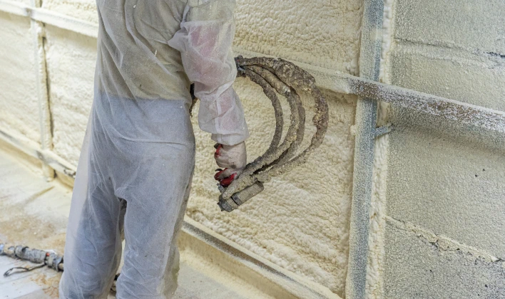 Spray foam technician applying product.